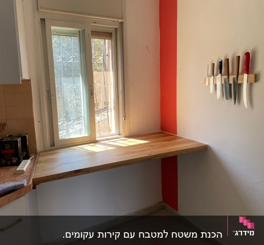שולחן עץ עם סכינים על הקיר במטבח